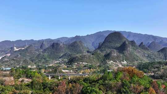 阳光下桂林高山下铁路桥上行驶的高速列车