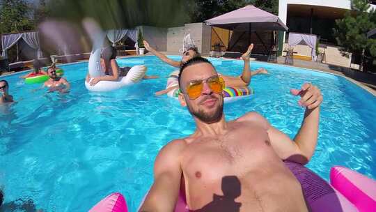 生活方式博客男子在游泳池里用动作相机自拍