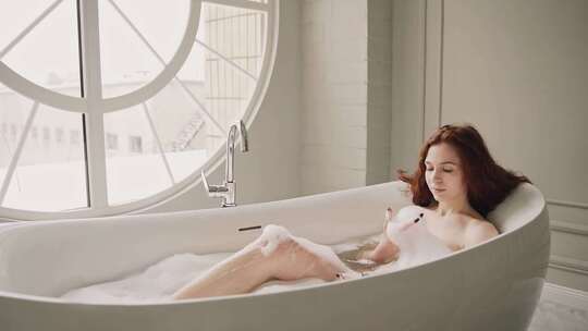 美女在窗边浴缸沐浴