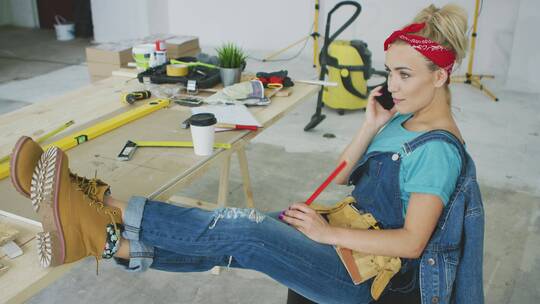 工作场所的女木匠用智能手机聊天