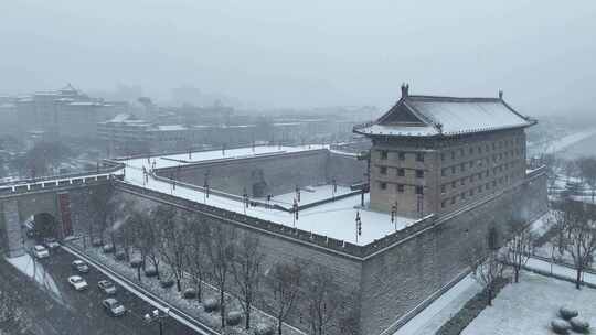 航拍陕西省西安市大雪中的西安安远门古城墙
