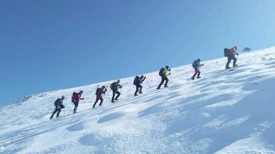 一群登山者在雪山山顶行走