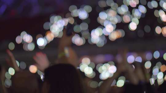 现场活动中观众中的灯光、挥舞的手臂和手机
