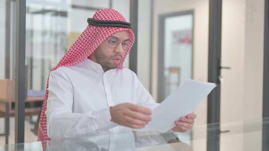 年轻的阿拉伯男子在阅读合同时感到不安视频素材模板下载
