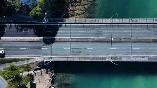 汽车和行人穿过横跨清水风景小溪的桥梁。无人机视图d