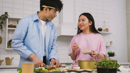 在厨房里烹饪和切食物的情侣视频素材模板下载