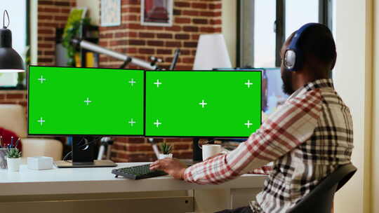 非裔美国人在家工作，显示屏上有绿屏