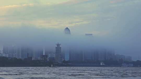 雾中城市景观，水域旁高楼若隐若现