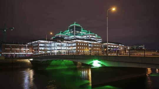 阿尔斯特银行大楼的时间推移在晚上被利菲河上桥梁上的交通照亮