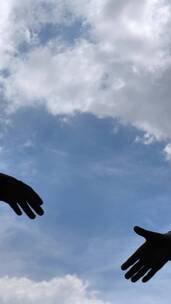 两个人与背景中的天空握手