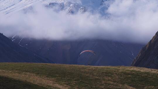 山脉里滑滑翔伞的人视频素材模板下载