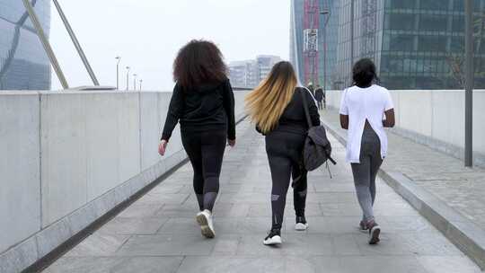 三个并排走路的女人背影