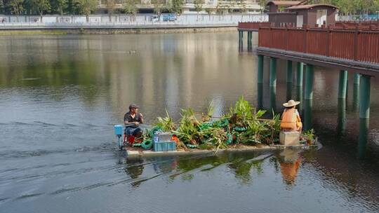 清理湖面垃圾的水上小船环卫工