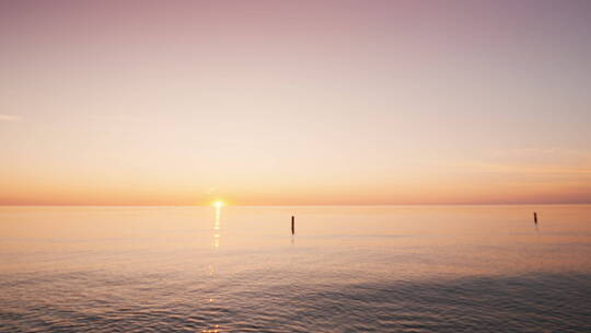 日落下海边手举帆船的镜头 