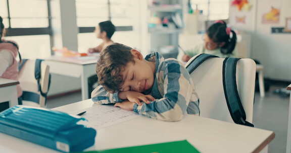 疲倦、睡觉和孩子在教室、幼儿园伏案或在学