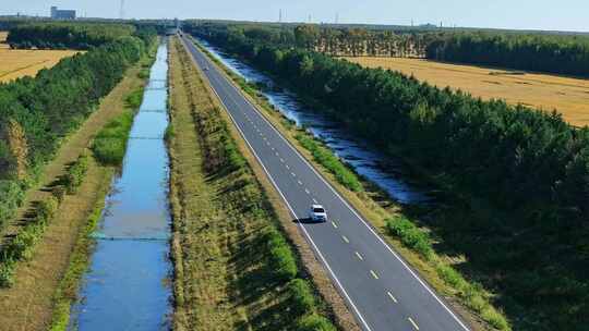 穿过树林与农田的公路航拍