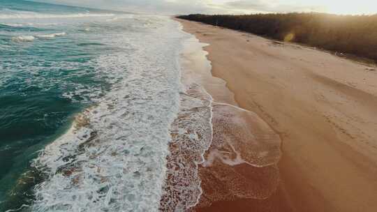 航拍海滩，海浪拍打沙滩