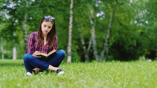 在草坪上读书的女人