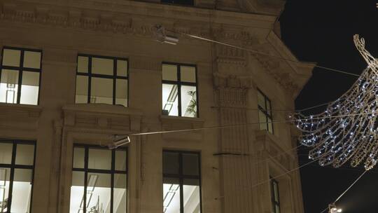 夜间伦敦摄政街商店的天使装饰灯
