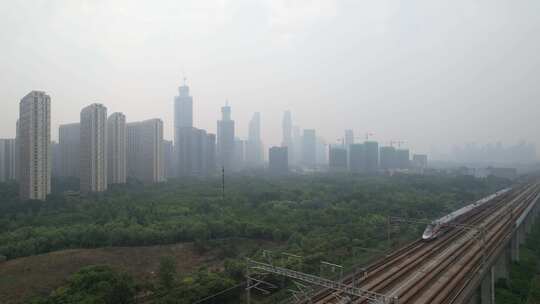 雾霾天高铁开过城市边缘航拍