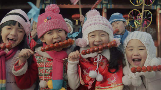 拿着糖葫芦面对着镜头微笑的女孩