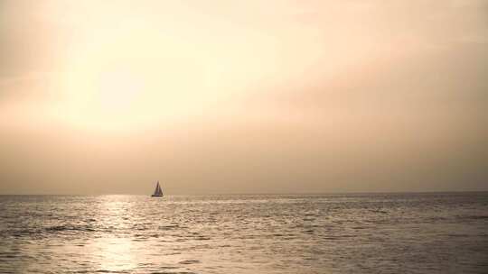 特写日落下海平面上漂流的帆船