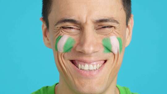 脸上画着尼日利亚国旗微笑的男人