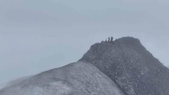 航拍登顶岷山山脉主峰雪宝顶雪山的登山者