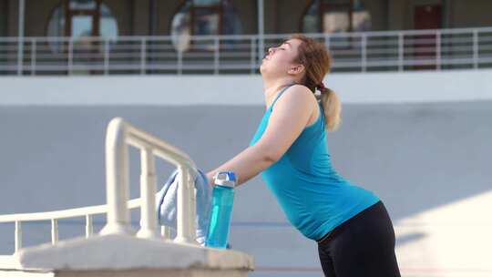 疲惫的胖女人慢跑者在跑步时呼吸