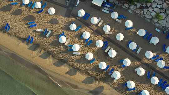 自上而下的空中放大塞浦路斯海滩的床和雨伞