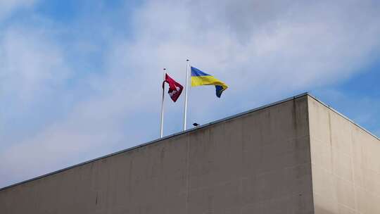拉脱维亚和乌克兰的国旗在拉脱维亚的一座大型混凝土建筑上一起飘扬