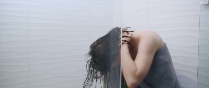 女人在淋浴时用毛巾包裹湿头发