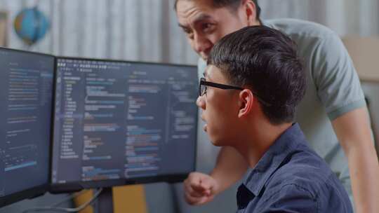 亚洲男生向男老师或父亲学习软件代码的特写