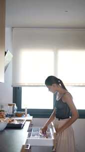 一名年轻女子在现代厨房准备早餐，自然光营
