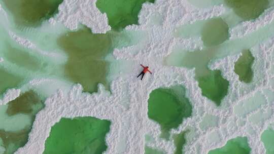 航拍男人躺在青海茫崖翡翠湖的盐池中