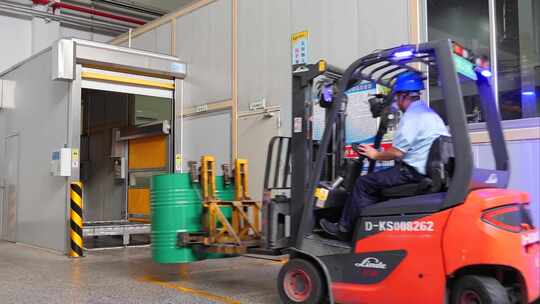 工人驾驶叉车搬运油桶