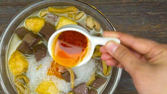 鸭血粉丝汤放入多种调料搅匀