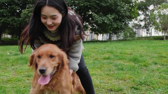 美丽女孩和宠物犬在公园里玩耍美女抱起狗狗