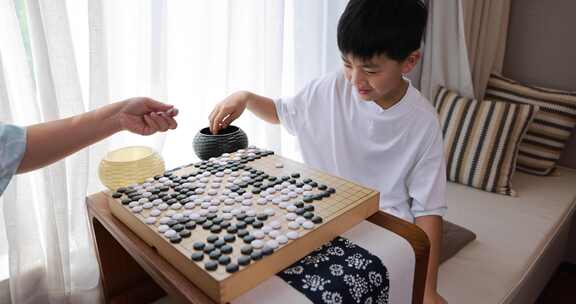 可爱的男孩在窗边下围棋