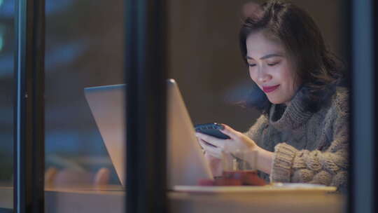 白领女孩夜晚城市咖啡馆用电脑看手机办公视频素材模板下载