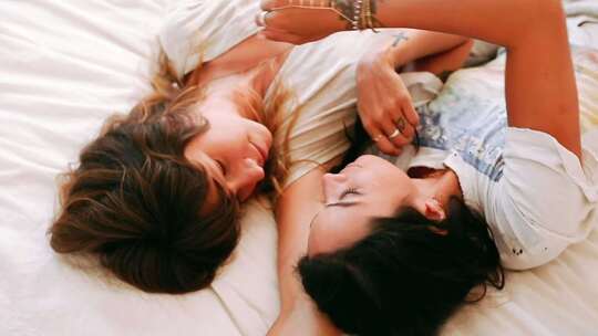 两位女性在床上拥吻