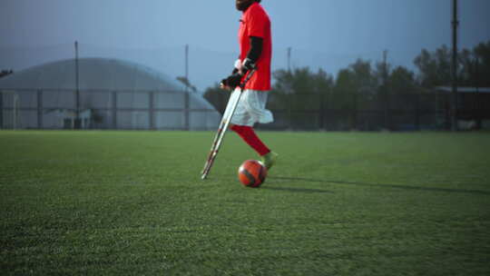 带球和拐杖的残疾人足球石膏腿