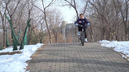 冬季在公园骑自行车的东方女孩