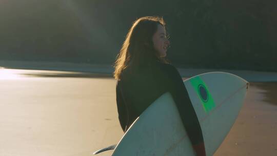 女孩抱着冲浪板走向海洋