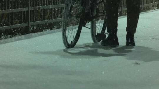 雪地里推着自行车行走的脚步