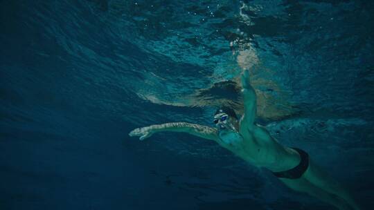 男性潜水运动员在水下游泳