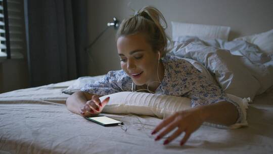 女人在床上听音乐视频素材模板下载