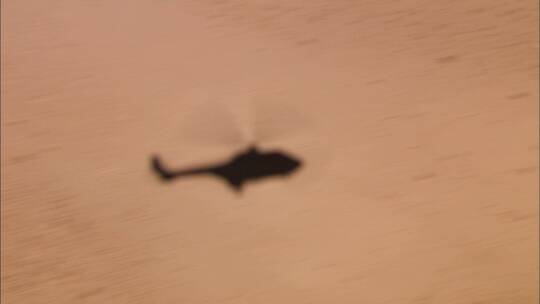 飞行直升机在沙漠地板上的阴影