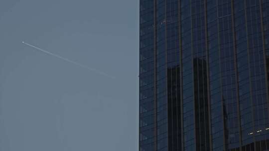 写字楼旁飞机划过天空