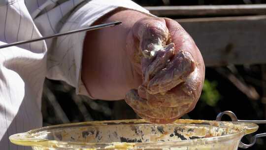 胖子把腌制的生肉放在串上做烤肉串视频素材模板下载